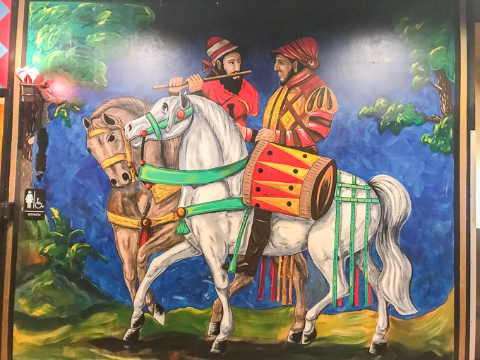 A mural of two knights on horses painted on a wall at Medieval Times.