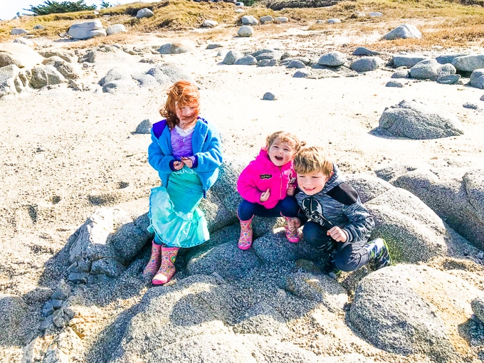 Three kids on the beach in Pacific Grove.