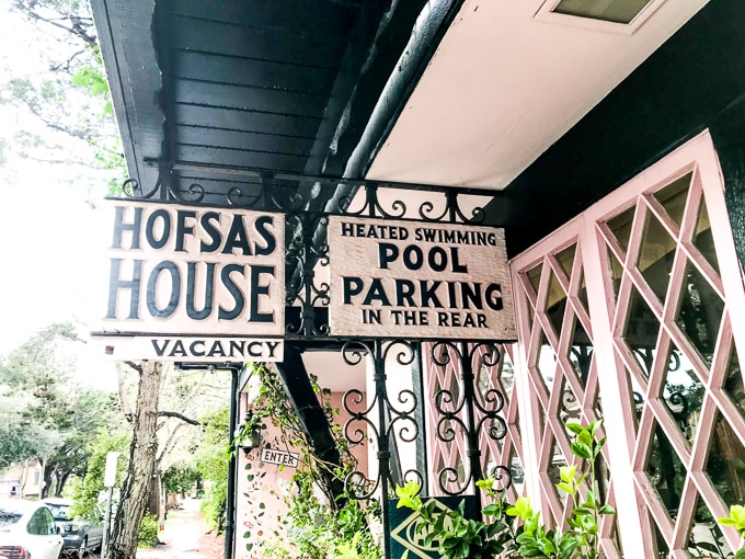 The two signs in front of Hofasa House, one advertising Hofsas House and the other advertising their pool and parking.