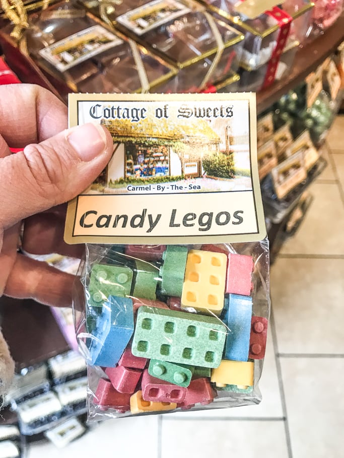 A hand holding a bag of candy LEGOs at Cottage of Sweets.