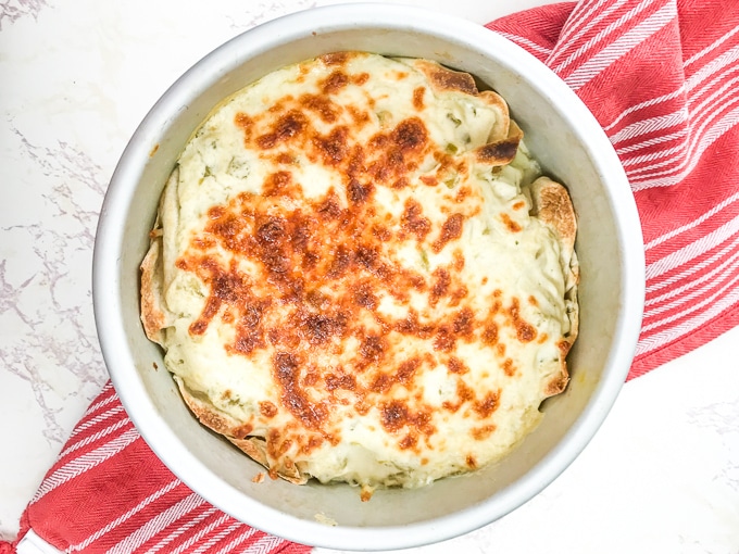 A round cake pan filled with instant pot chicken enchiladas.