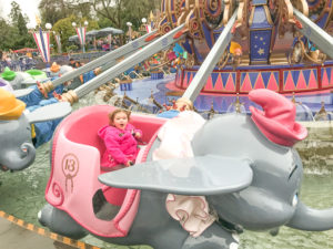A little girl riding the Dumbo ride at Disneyland in Winter.