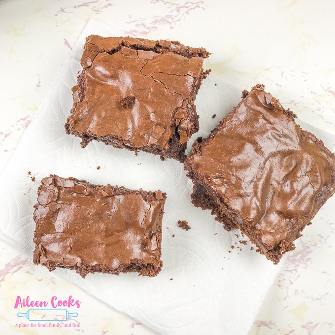 Three chocolate chunk brownies on top of a paper towel.