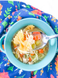 A bowl of the instant pot chicken noodle soup recipe with a spoon lifting up a bite.