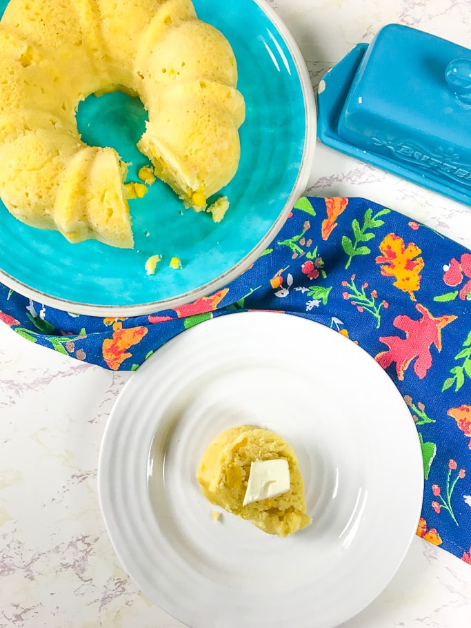 A slice of instant pot cornbread with a pat of butter.