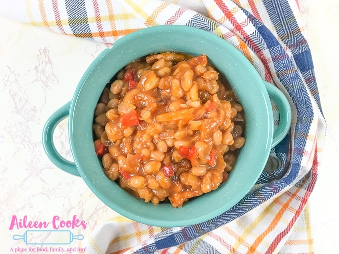 A teal bowl filled with instant pot baked beans.