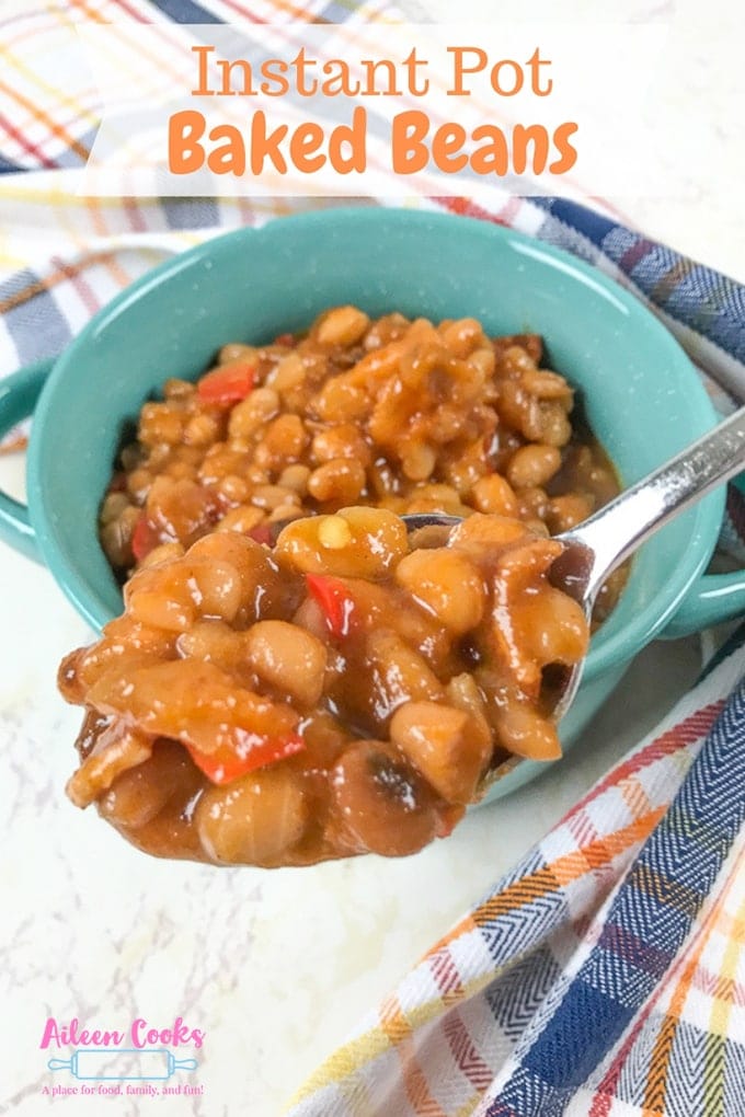 A close-up of a spoonful of instant pot baked beans over a bowl filled with baked beans.