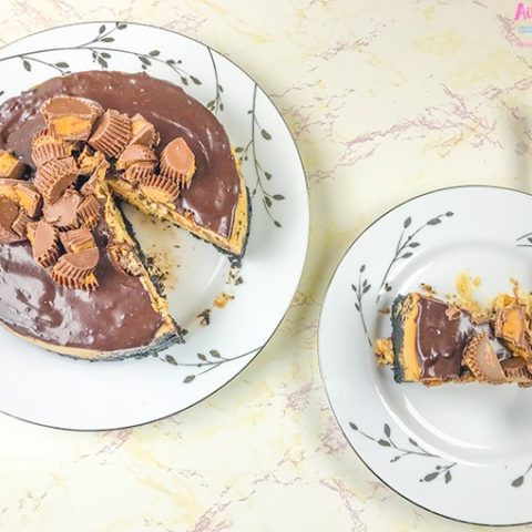 A plate of peanut butter cup cheesecake next to the entire cheesecake.