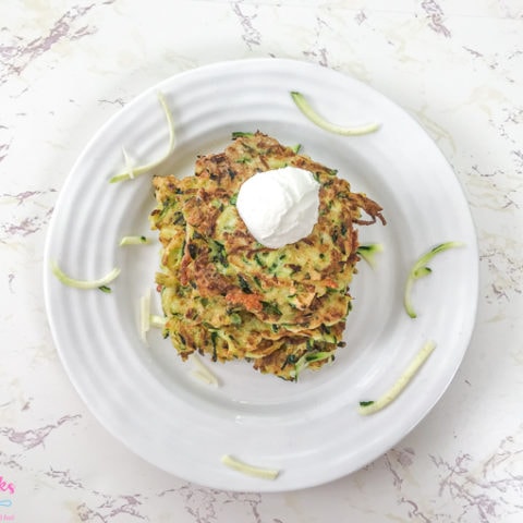 Zucchini fritters on a white plate.