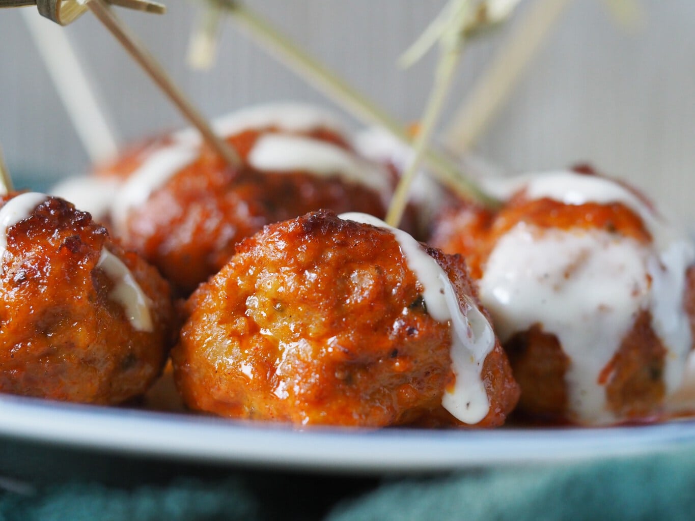 A close up of buffalo meatballs with toothpicks sticking out of the otp.