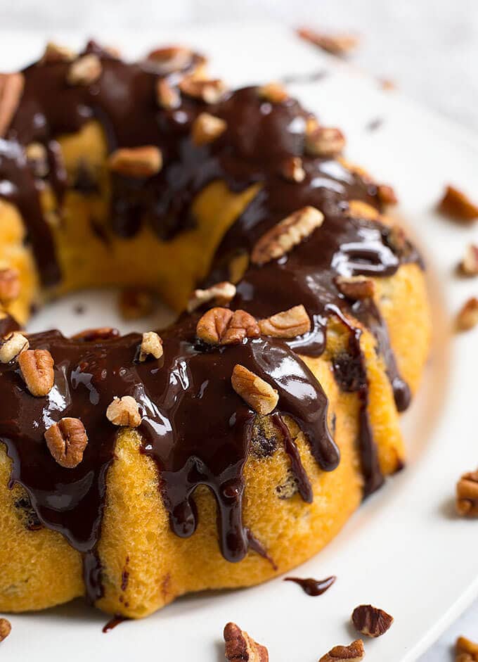 A chocolate covered Bundt Cake on a white plate.