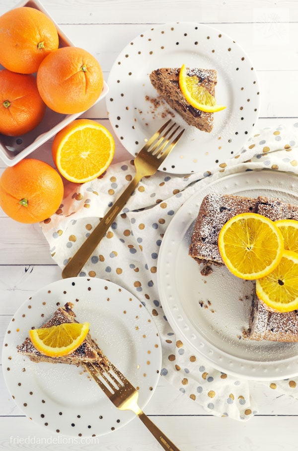 Two plates of spice cake topped with orange slices.