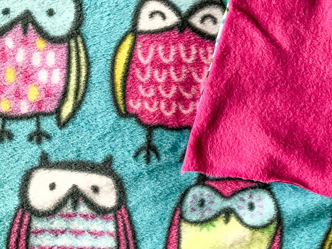 Owl fleece fabric with coordinating pink fleece fabric on top.