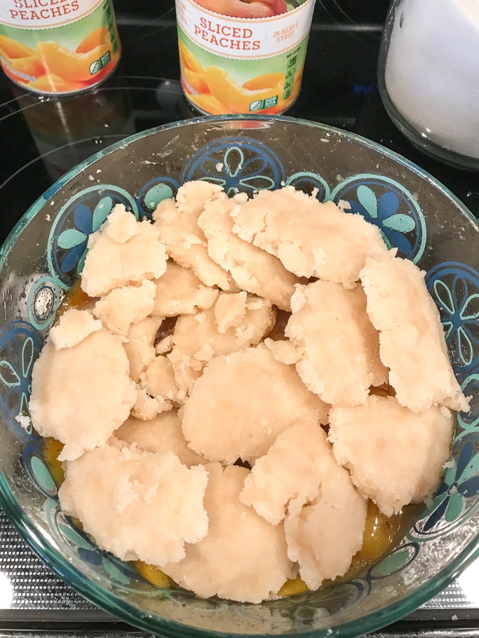 Uncooked instant pot peach cobbler in a glass cake pan.