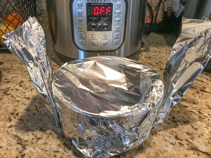 instant pot peach cobbler wrapped in foil and on top of a foil sling.
