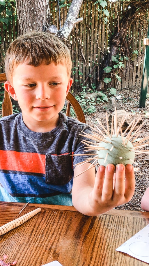 A boy holding his completed barrel cactus.