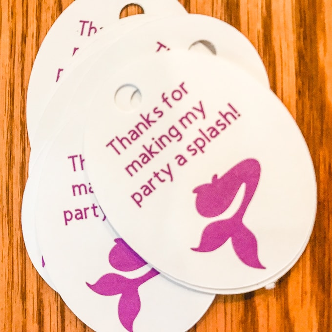 A stack of mermaid favor tags with the words "Thanks for making my party a splash" printed on the tags. 