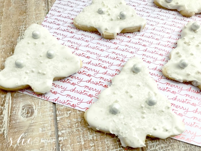 White chocolate Christmas tree cookies on a red and white towel.