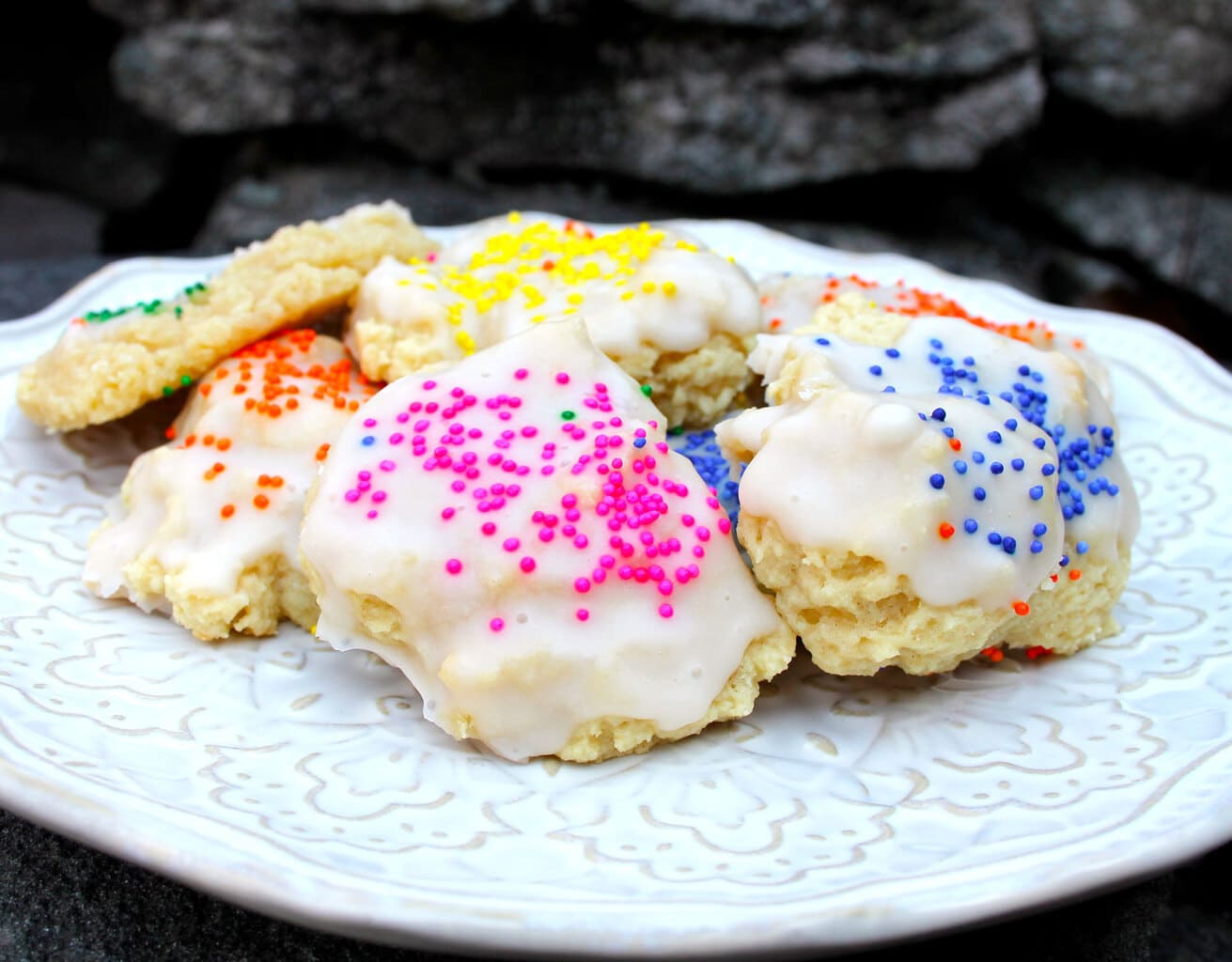 Colorful Italian ricotta cookies on a white plate.