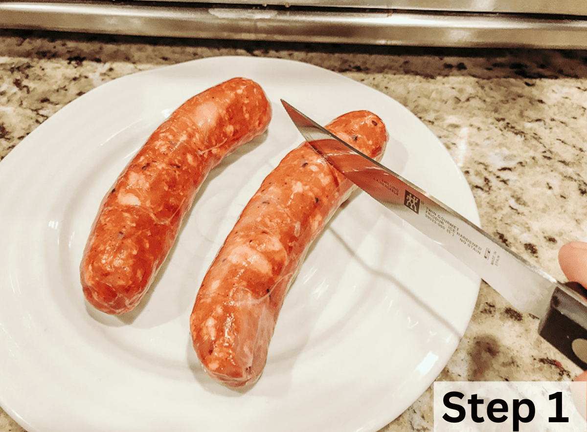 A white plate holding two smoked sausages with a knife cutting slits in the sausages.
