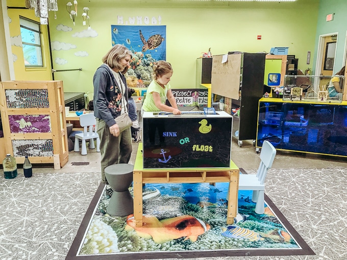 A little girl and her grandma playing in the Sink or Float exhibit.