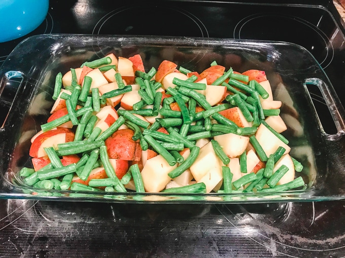 Red potatoes and green beans layered in a casserole dish.