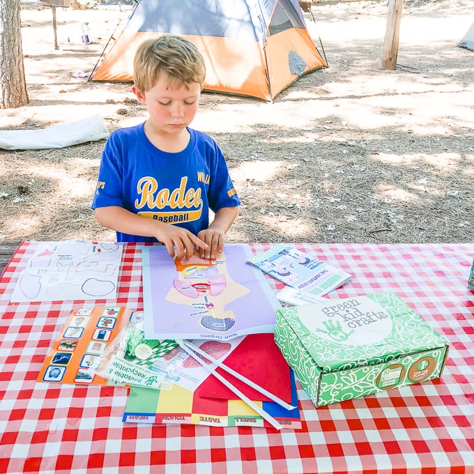 A boy working on the human body poster from the green kid crafts box.