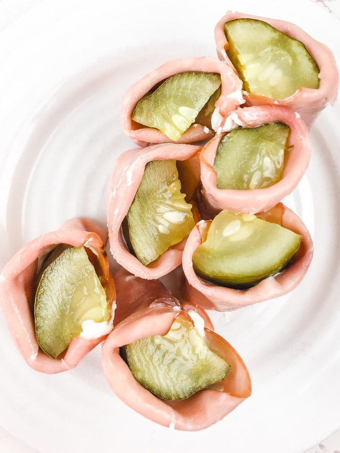 Close up of the pickles inside of ham and cream cheese roll-ups.