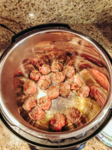Browned meatballs inside the instant pot.