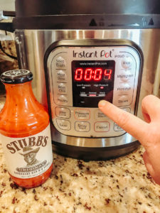 A hand setting the instant pot to high pressure 4 minutes.