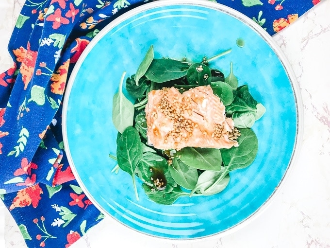 A blue plate with teriyaki salmon that was made in the instant pot.