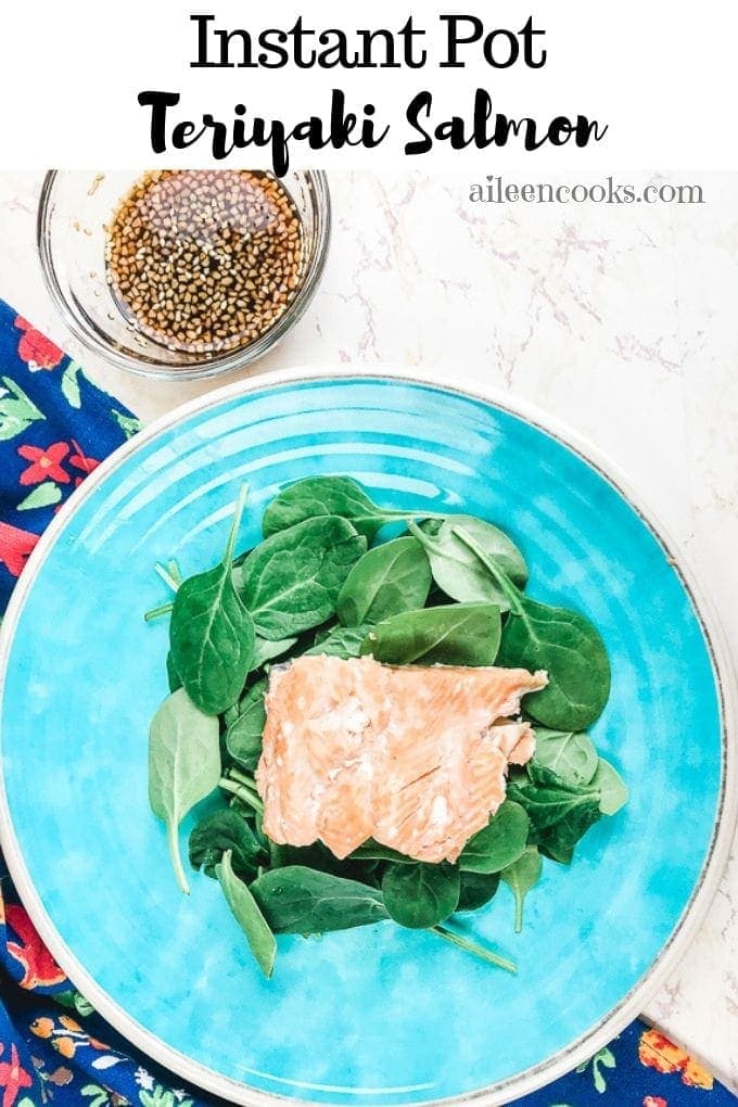 instant pot salmon on a blue plate next to a glass blow of homemade teriyaki sauce.