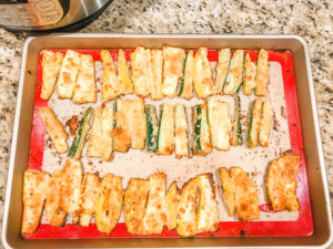parmesan zucchini fries on a cookie sheet.