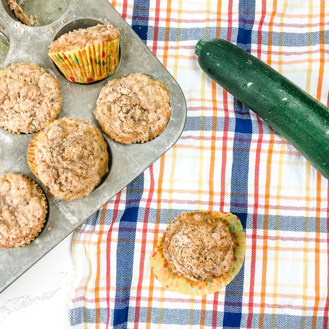 Chocolate chip zucchini muffins on a plaid tablecloth.