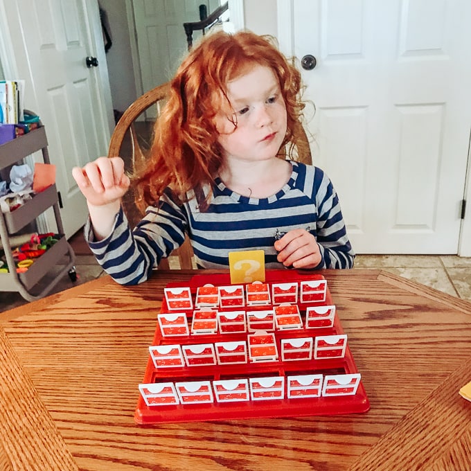 A red headed girl playing Guess Who.