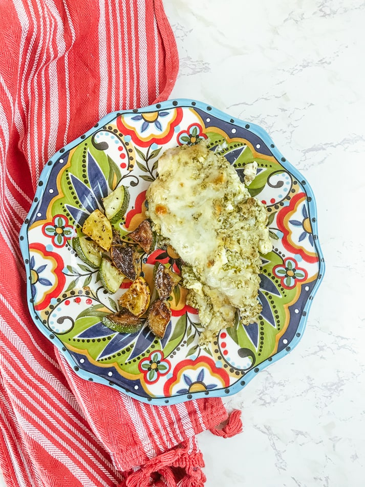 A colorful plate served with cream pesto chicken and roasted squash.