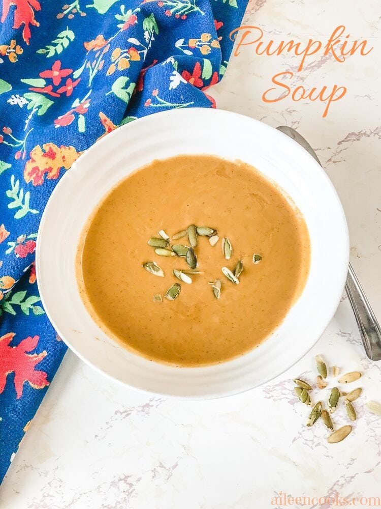 A bowl of pumpkin soup topped with papitas.