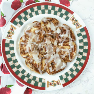 A red and green fall-themed plate topped with instant pot pillsbury cinnamon rolls.
