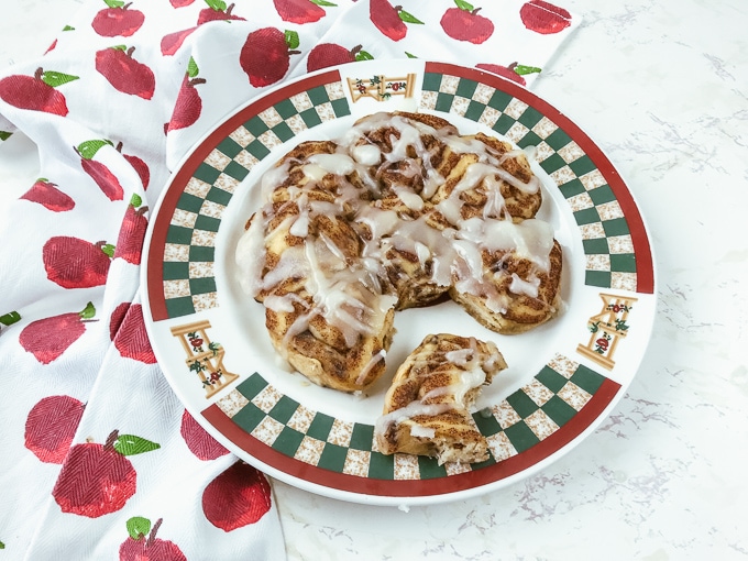 A plate of instant pot canned cinnamon rolls with one pulled off.