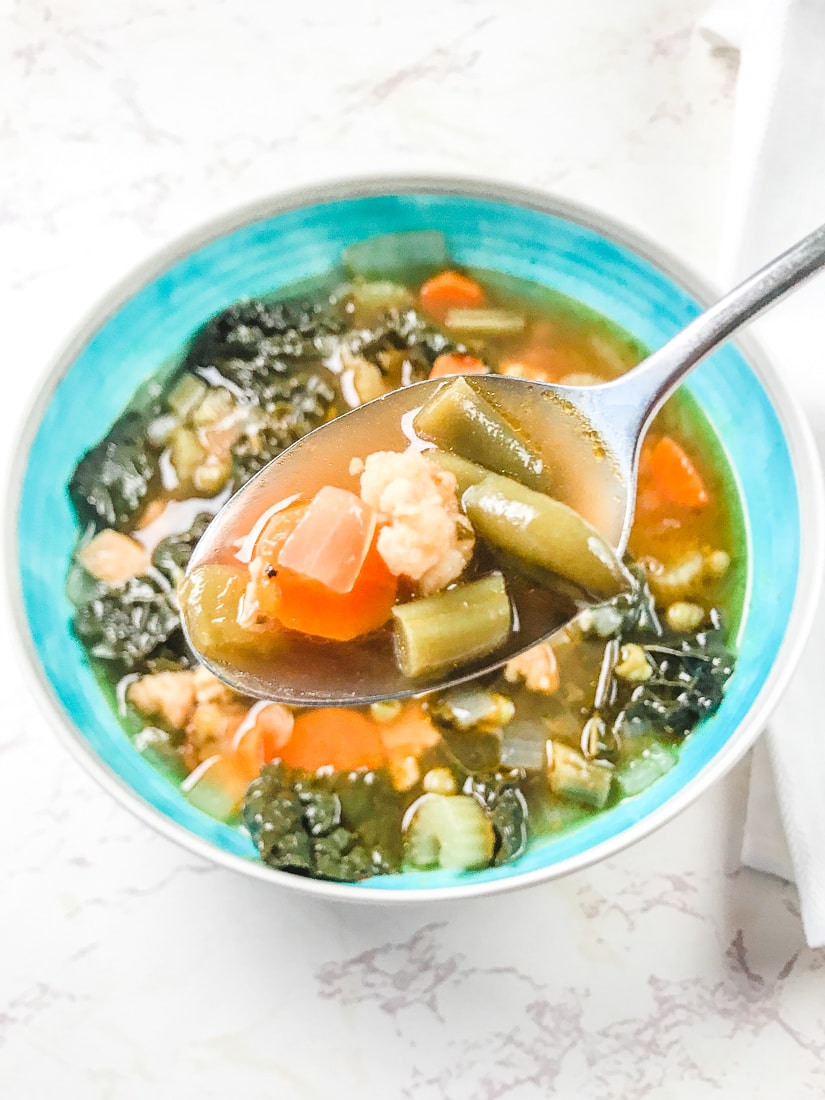 Bite of instant pot chicken vegetable soup on a spoon.