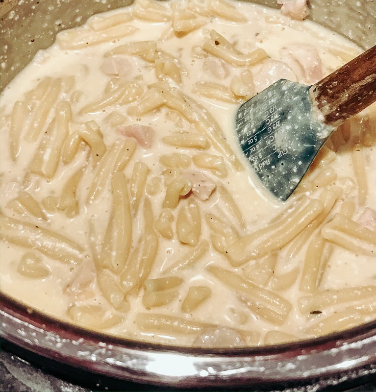 A rubber spoon mixing up crack chicken pasta in the instant pot.