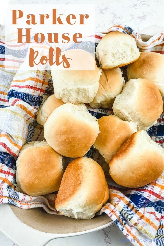 A basket full of dinner rolls with the words "Parker house rolls"