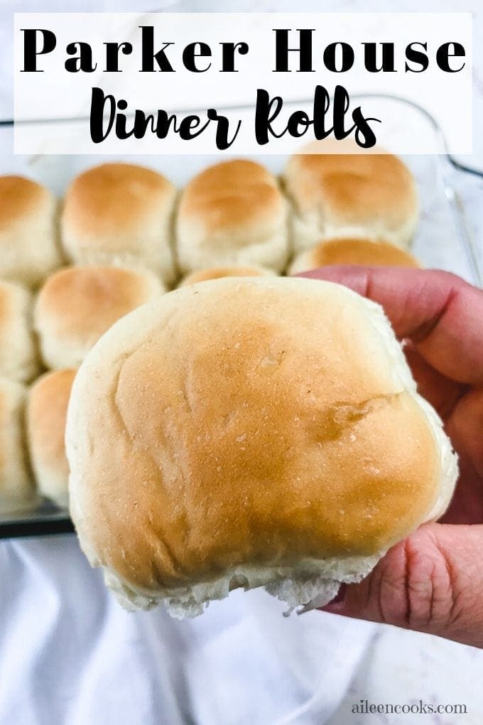 A hand holding a dinner roll with the words "Parker house dinner rolls"