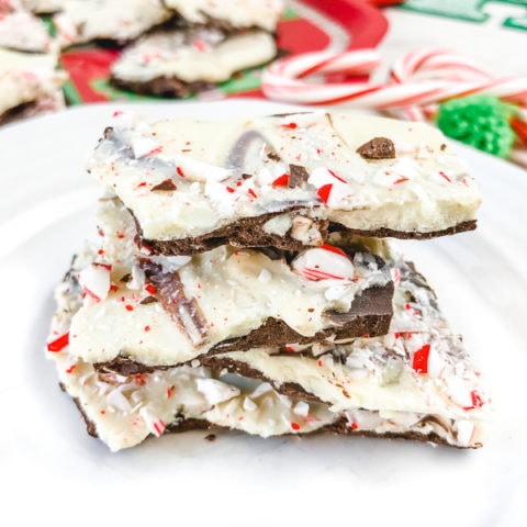 A stack of three pieces of peppermint bark on a white plate.