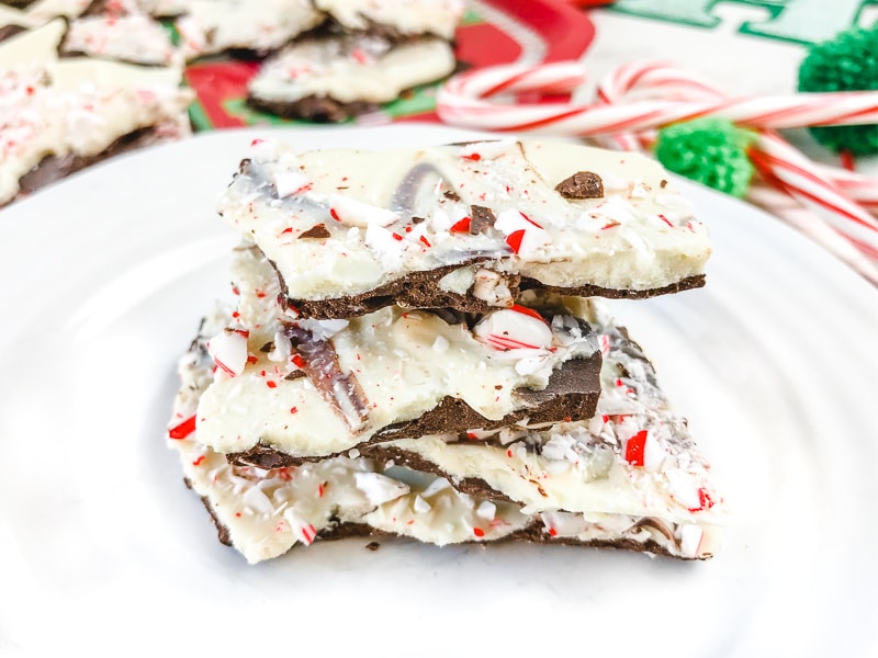 A stack of three pieces of peppermint bark on a white plate.