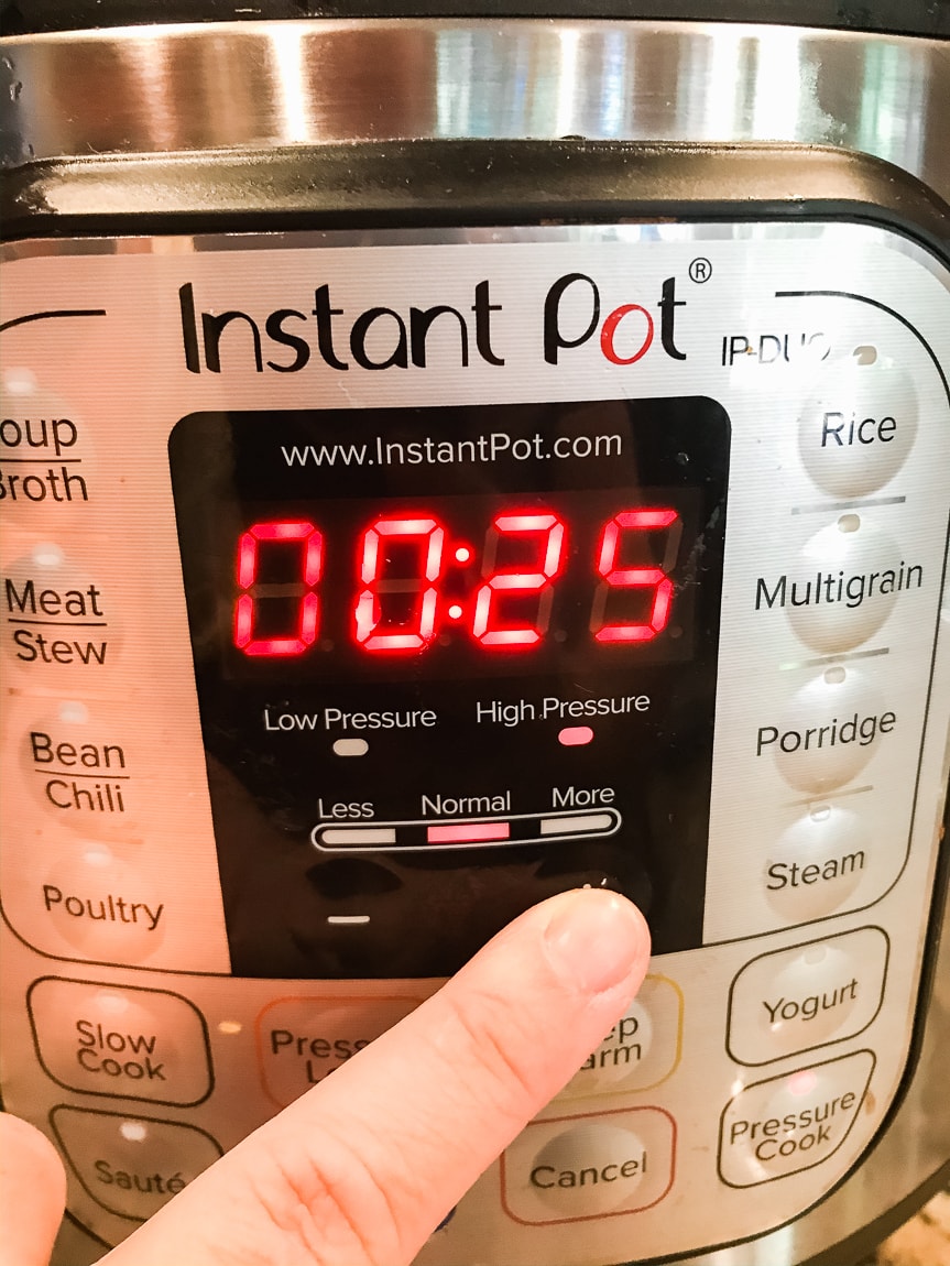 A finger setting the instant pot to 25 minutes.