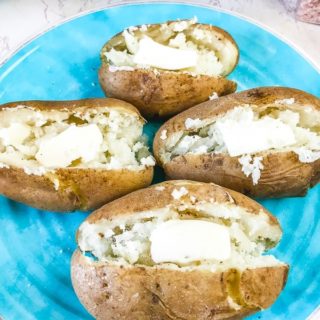 Overhead shot of instant pot baked potatoes slathered with butter.