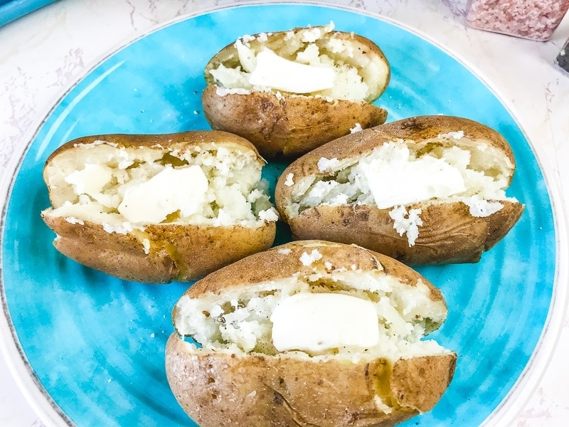Overhead shot of instant pot baked potatoes slathered with butter.