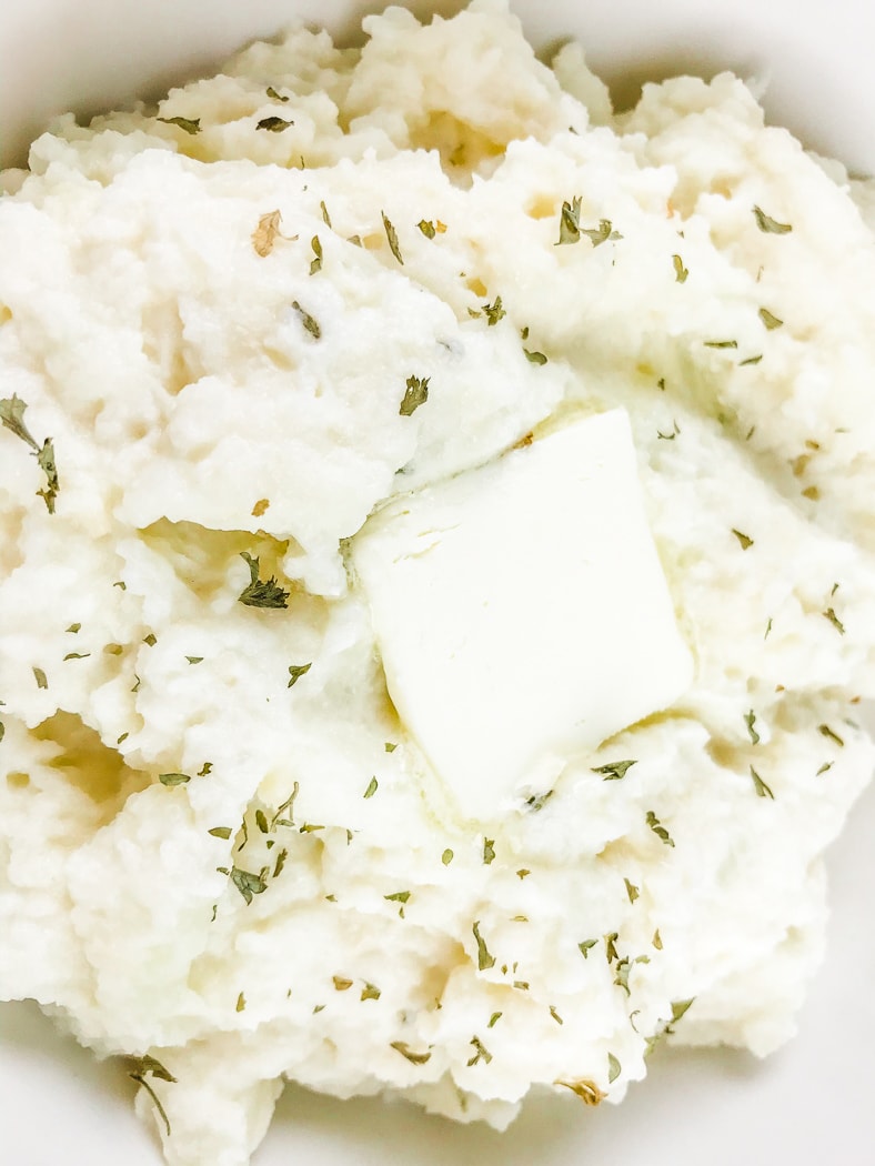 Close up of Keto cauliflower mashed potatoes with butter on top.