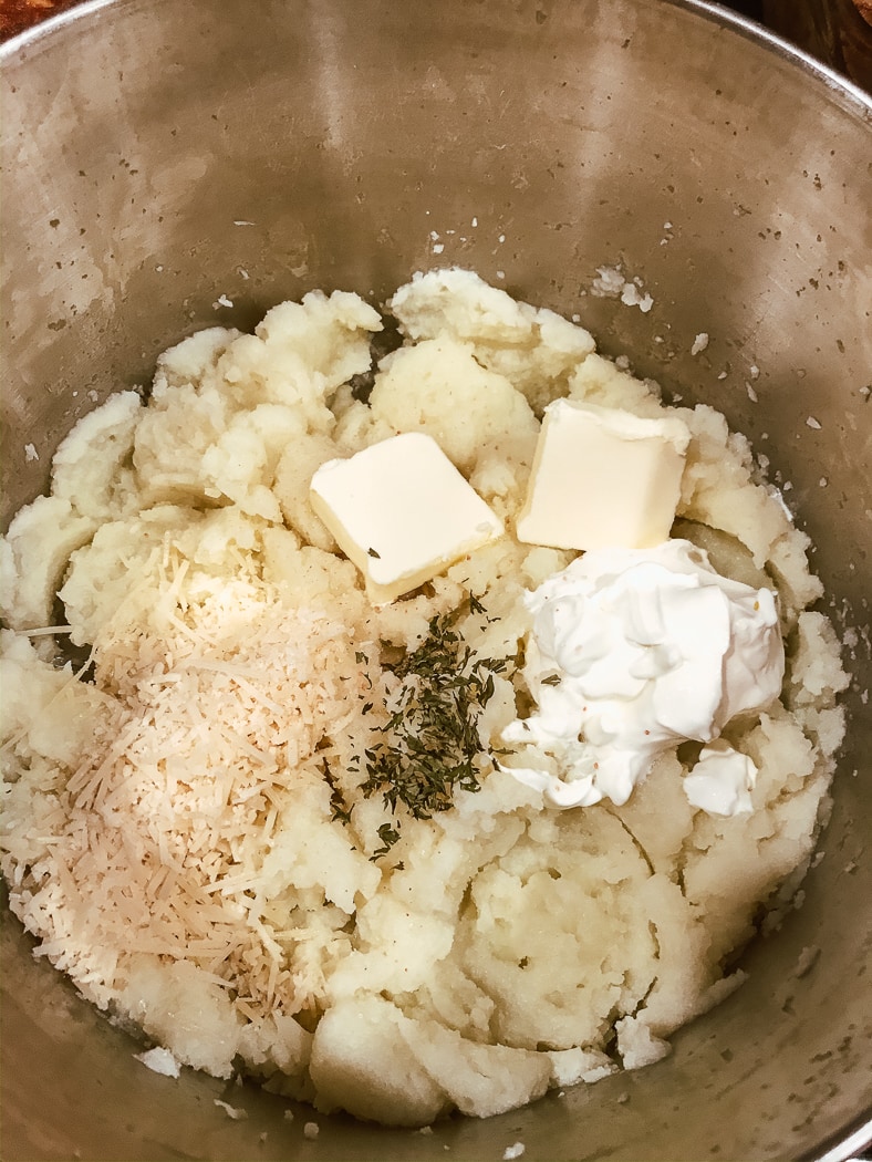 Boiled and blended cauliflower topped with butter, sour cream, parmesan, parsley, and salt.